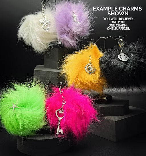 Colorful fluffy keychains with charms on a black background