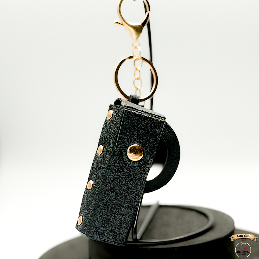 Black leather keychain pouch with gold accents on a white background
