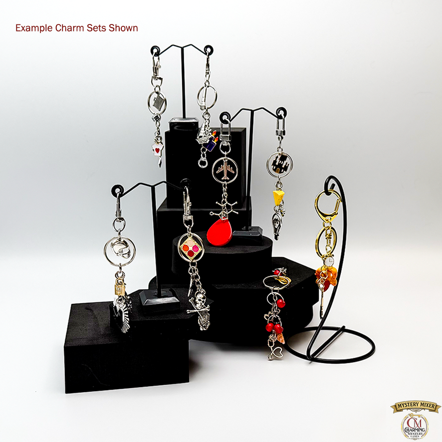 Jewelry charm sets on black stands with a white background