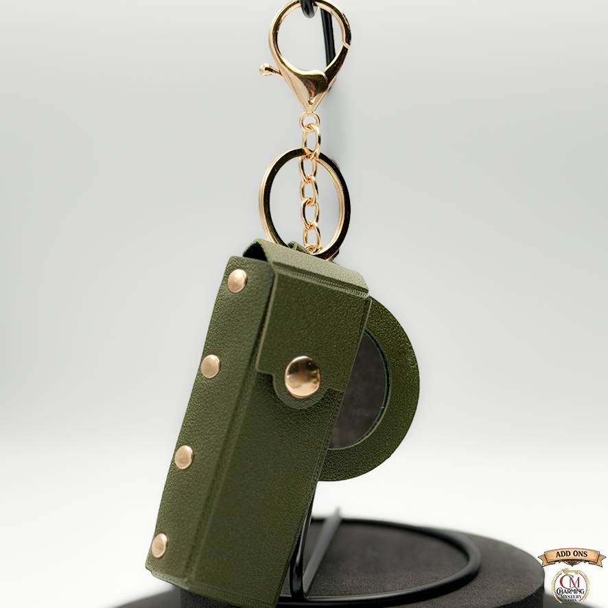 Green leather keychain with gold accents on a white background