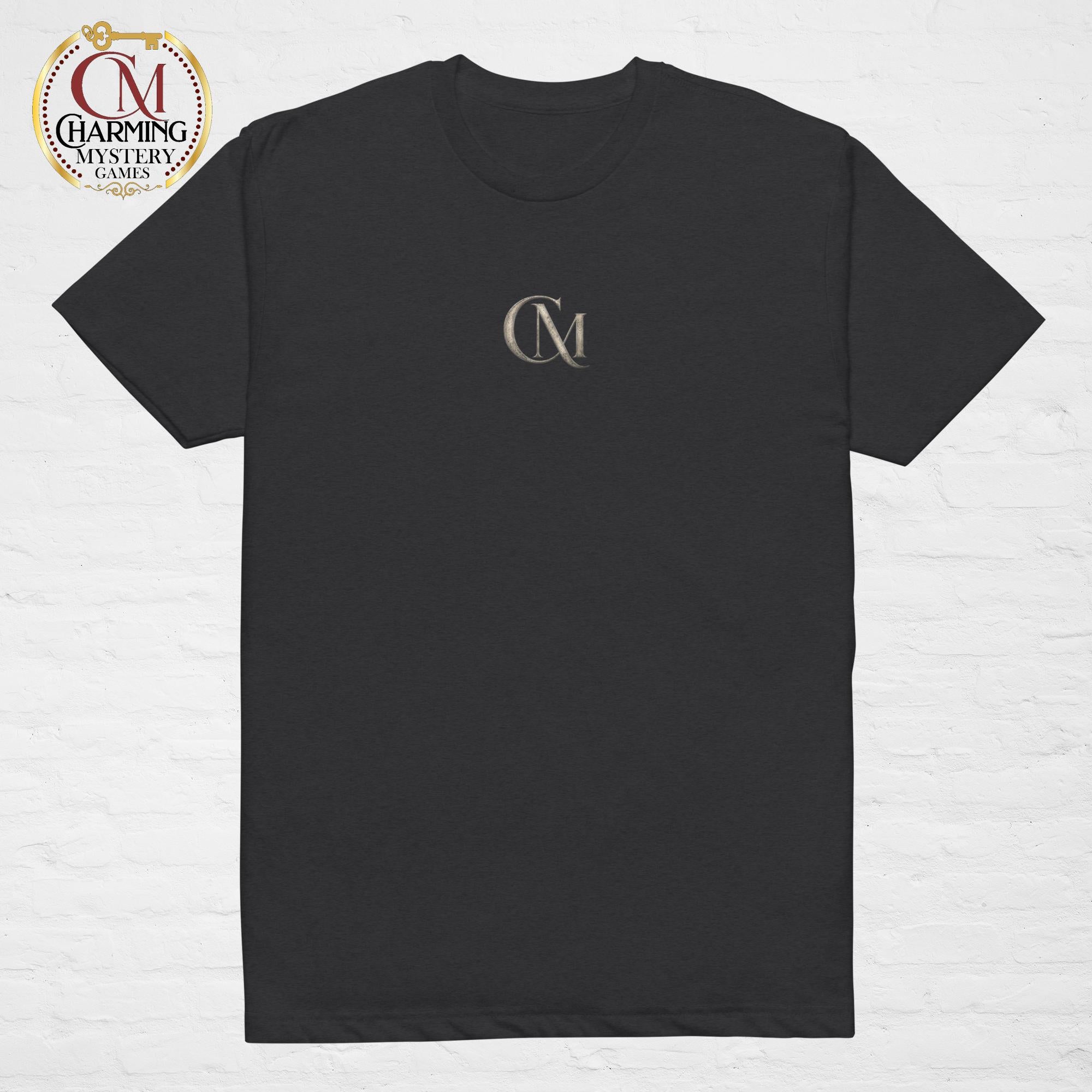 Product mockup of a black tee shirt that has a CM logo on it for Charming Mystery Games. 