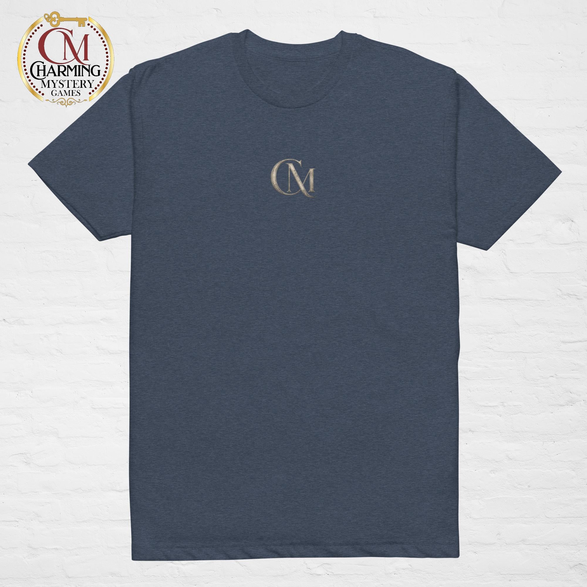 Product mockup of a blue tee shirt that has a CM logo on it for Charming Mystery Games. 
