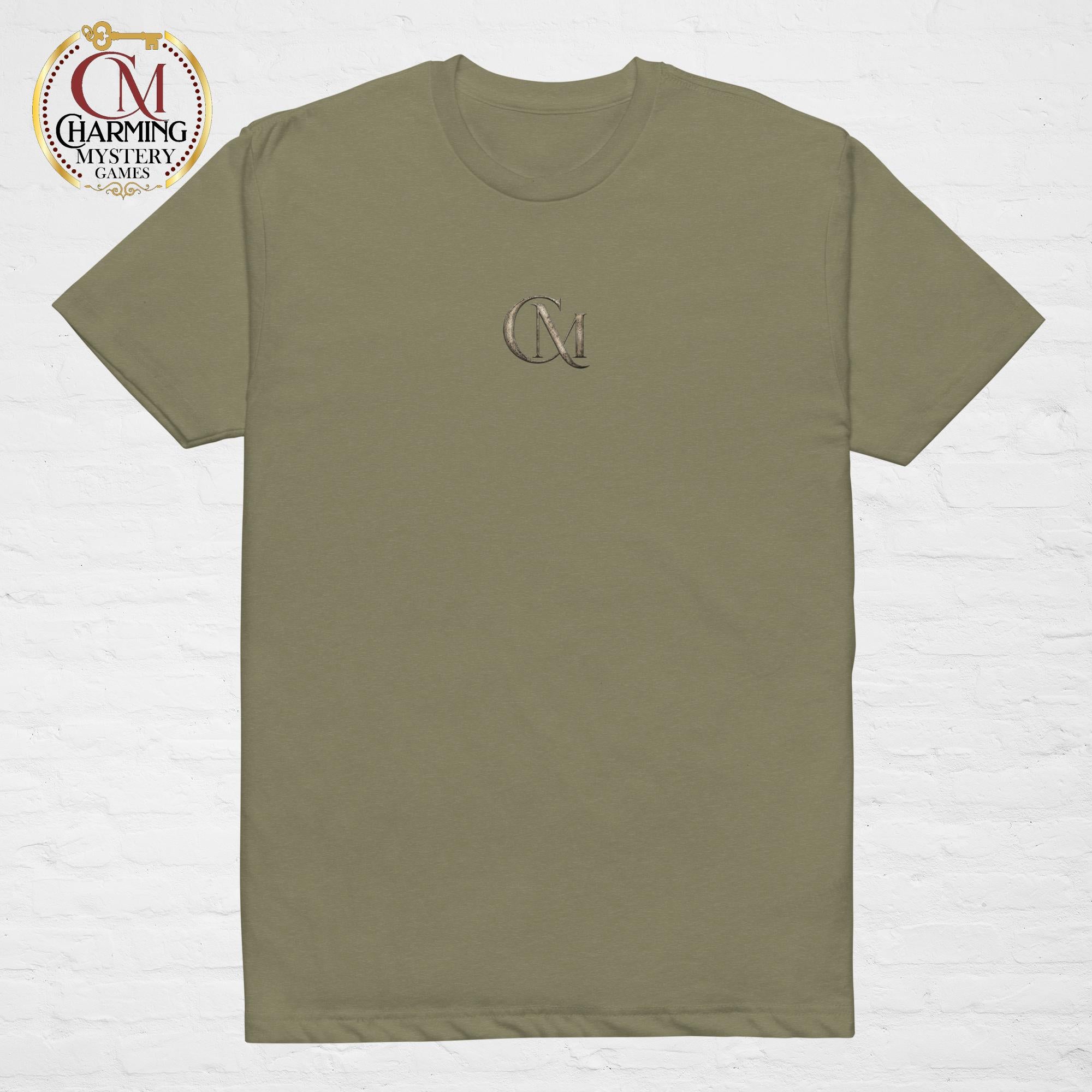 Product mockup of a green tee shirt that has a CM logo on it for Charming Mystery Games. 