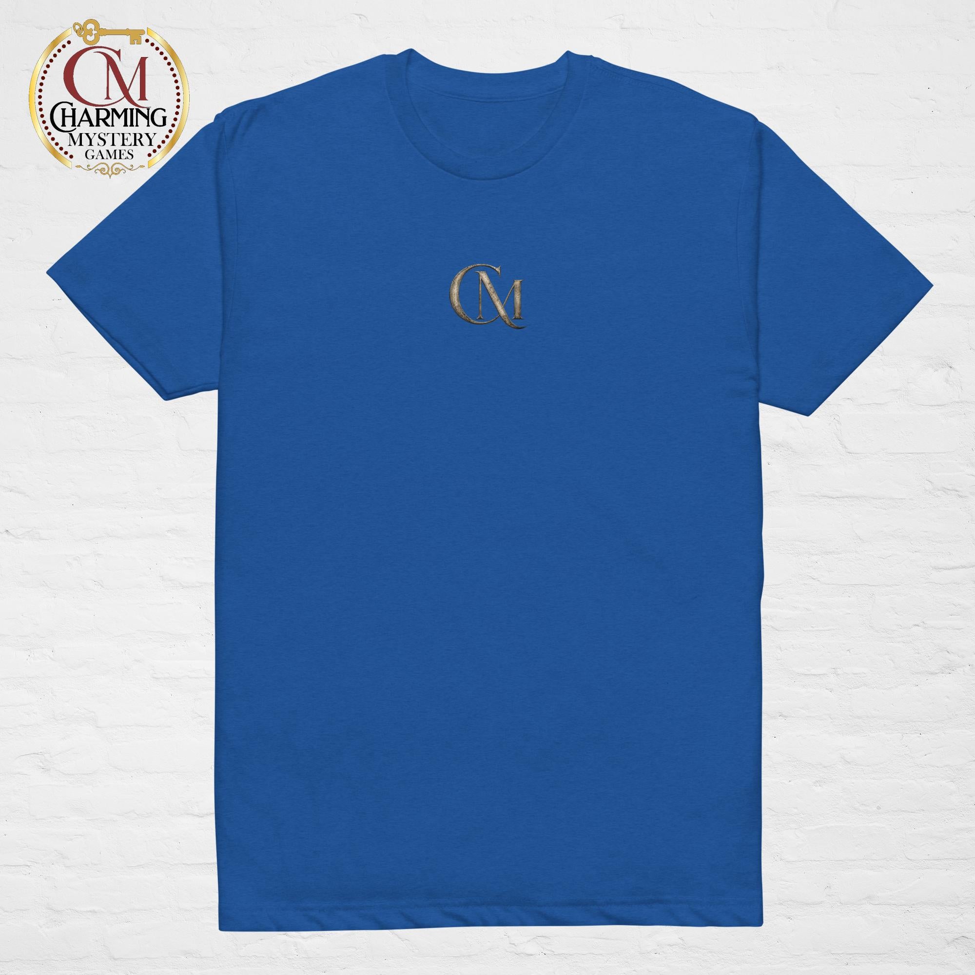 Product mockup of a blue tee shirt that has a CM logo on it for Charming Mystery Games. 